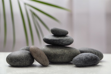 Photo of Spa stones on white table indoors. Zen and harmony