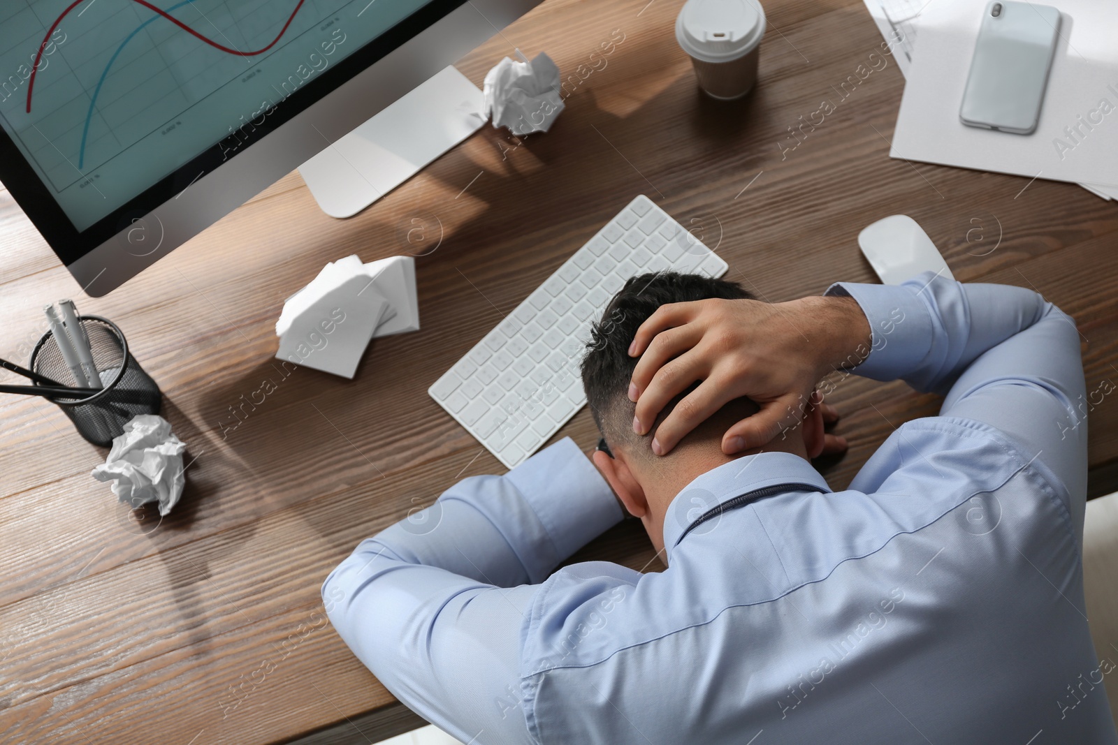 Photo of Stressed out businessman at workplace in office, above view