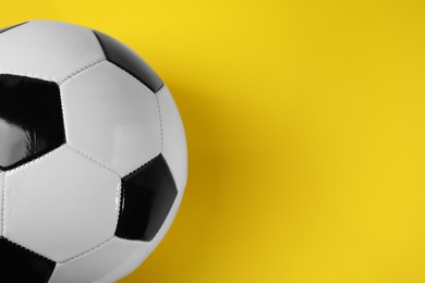 Photo of One soccer ball on yellow background, above view with space for text. Sports equipment