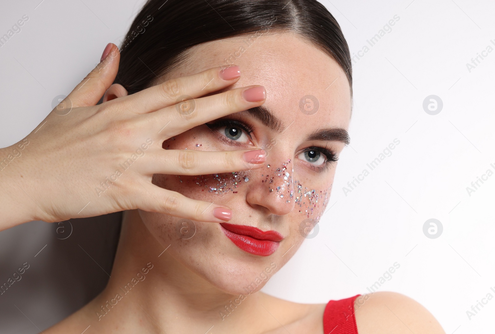 Photo of Beautiful woman with glitter freckles on white background, closeup