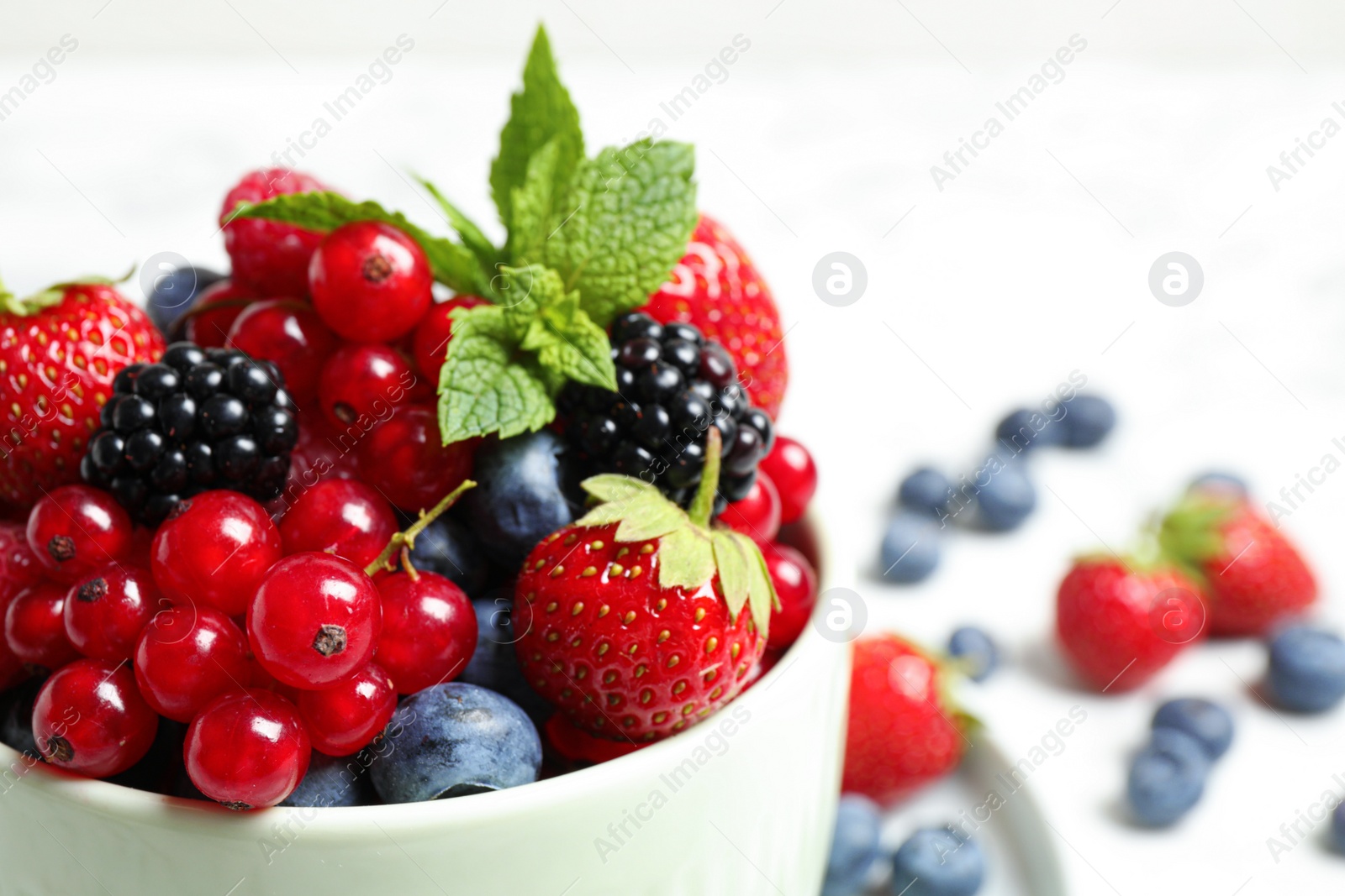 Photo of Mix of ripe berries in bowl, closeup