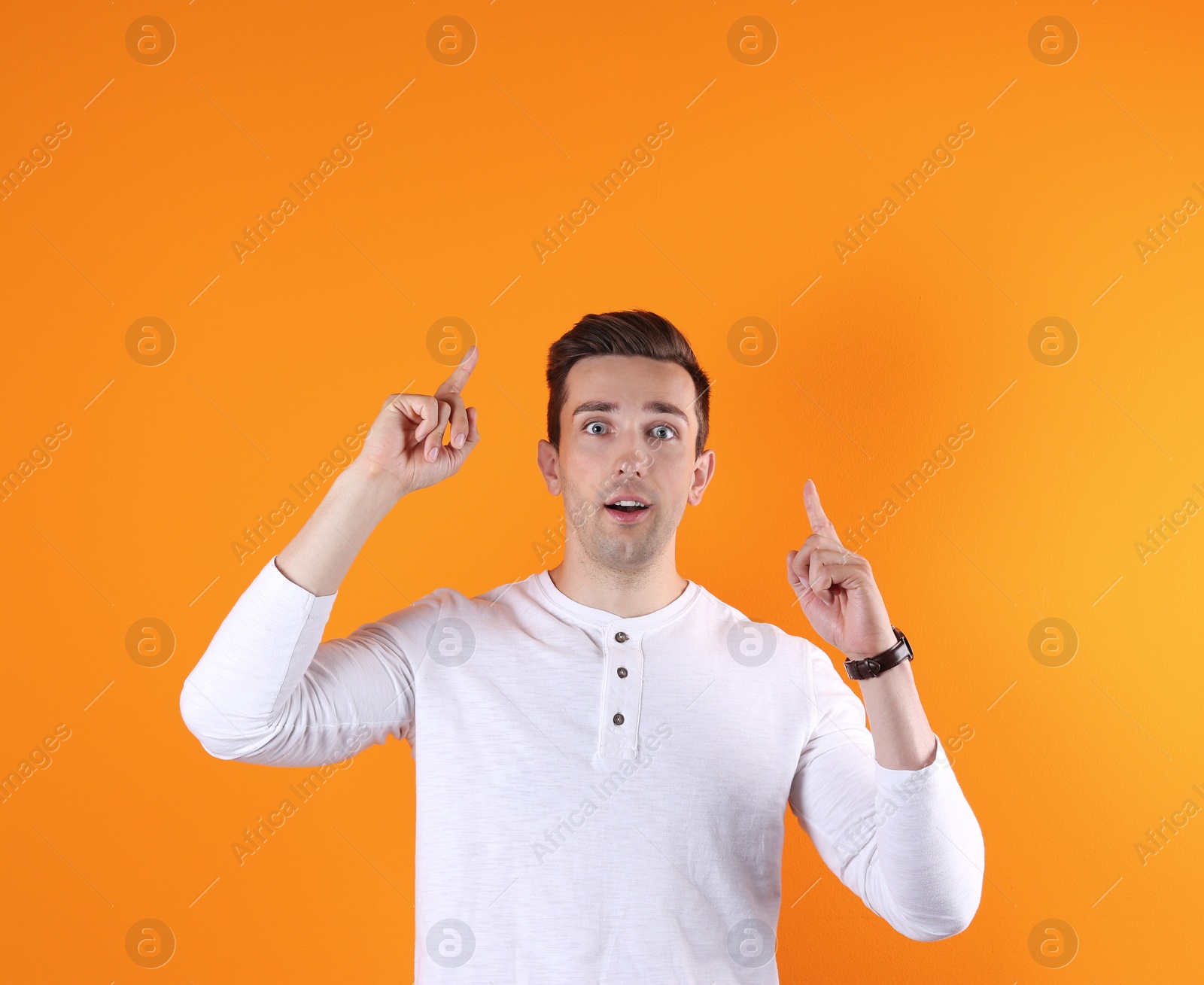 Photo of Handsome emotional young man on color background