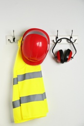 Photo of Different safety equipment hanging on white wall