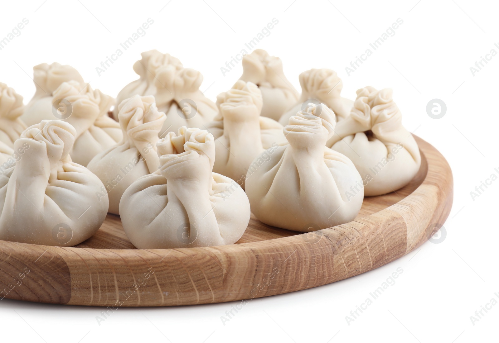 Photo of Wooden board with uncooked khinkali (dumplings) isolated on white. Georgian cuisine