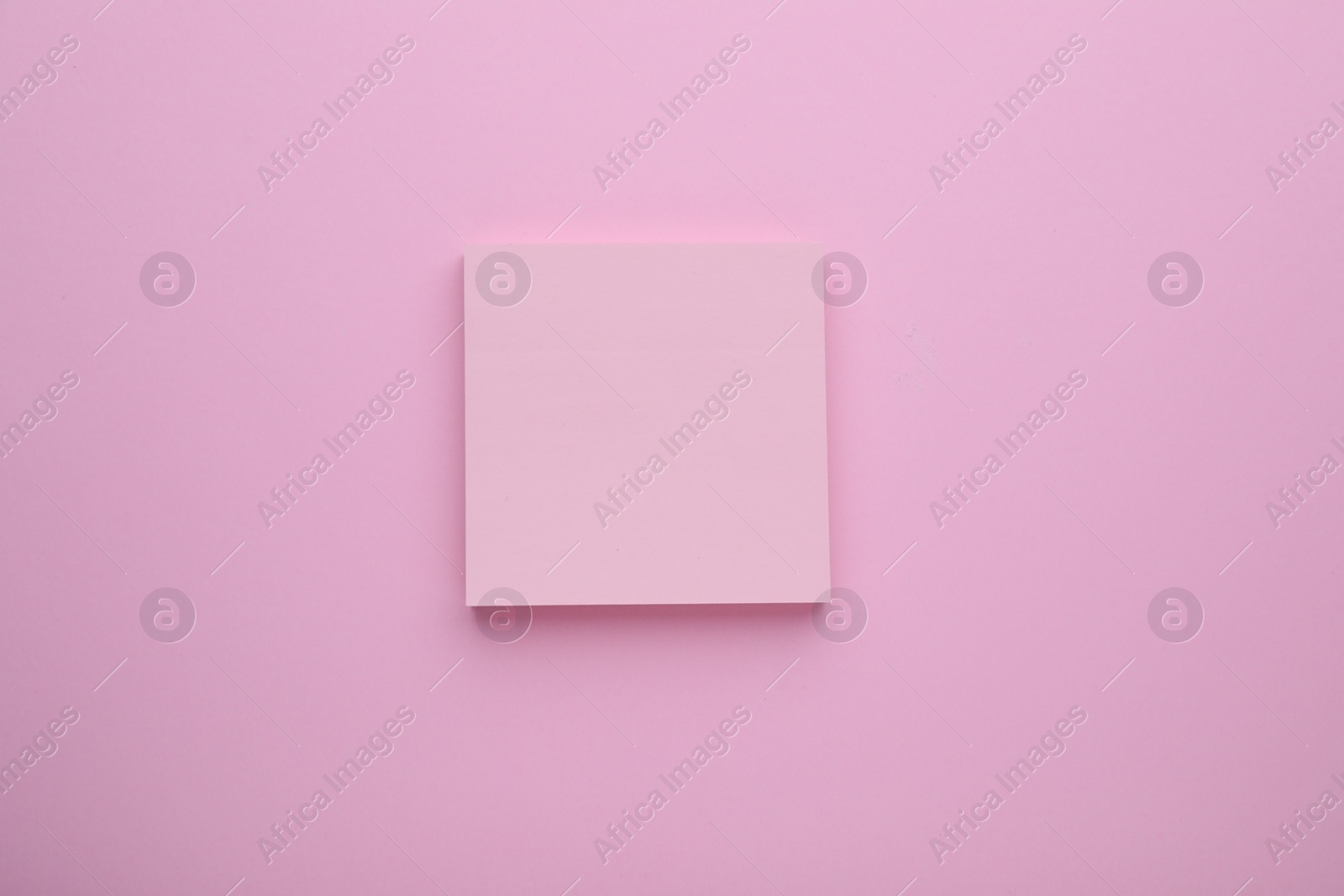 Photo of Paper note on pale pink background, top view