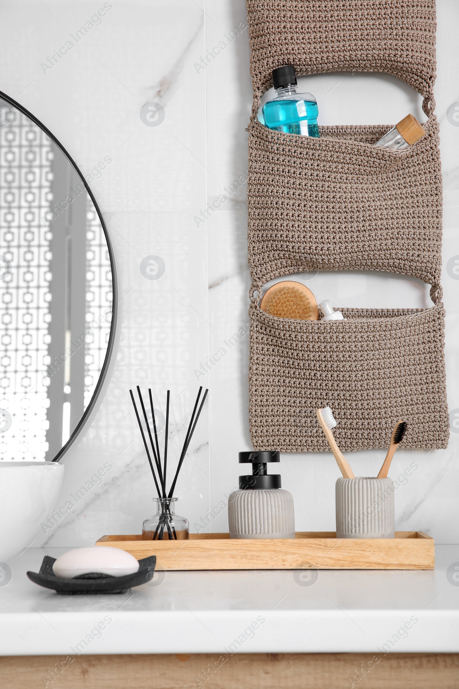 Photo of Knitted organizer hanging on wall in bathroom