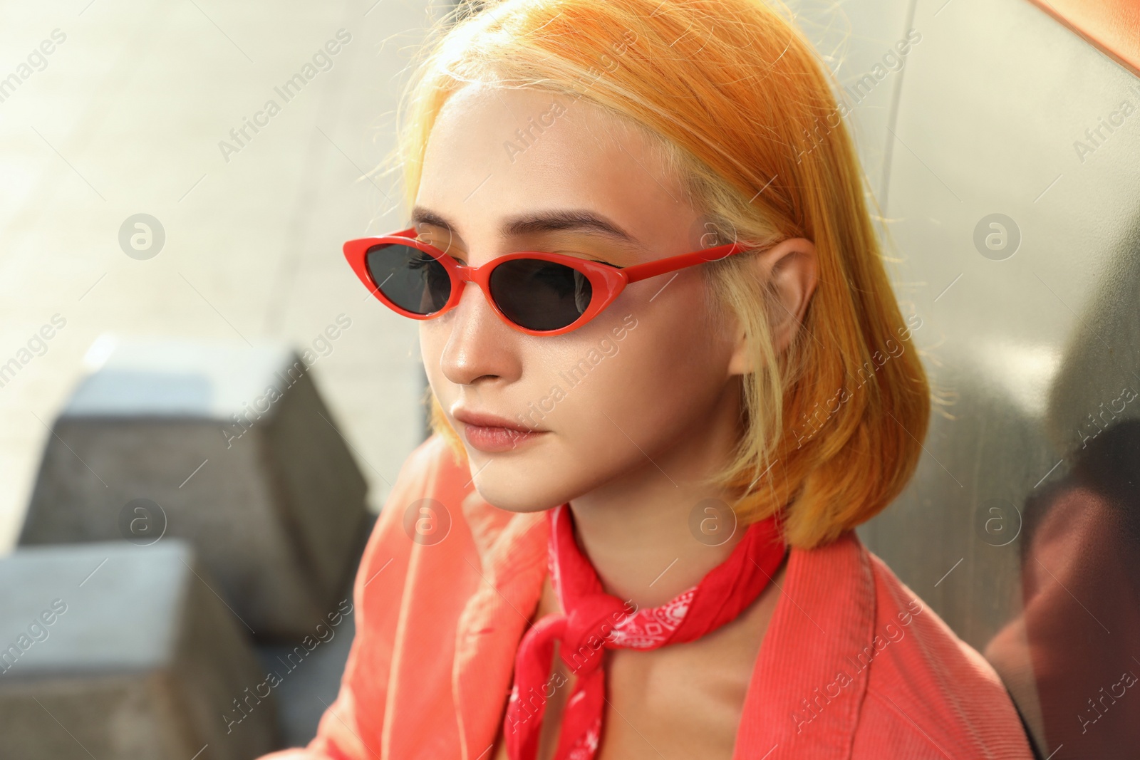 Photo of Beautiful young woman with bright dyed hair in sunglasses outdoors