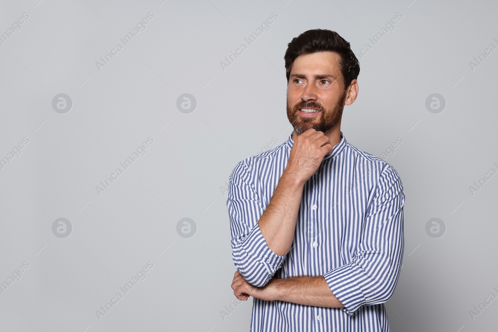 Photo of Portrait of handsome bearded man on grey background. Space for text