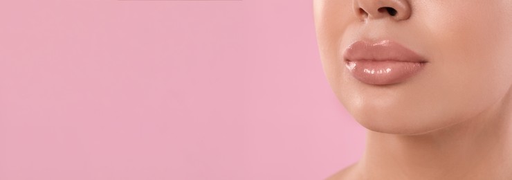 Image of Woman with beautiful lips on pink background, closeup view with space for text. Banner design