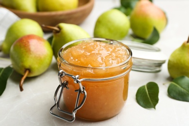 Photo of Delicious pear jam and fresh fruits on light grey table