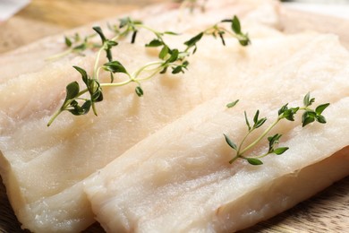 Photo of Raw cod fish and microgreens on board, closeup