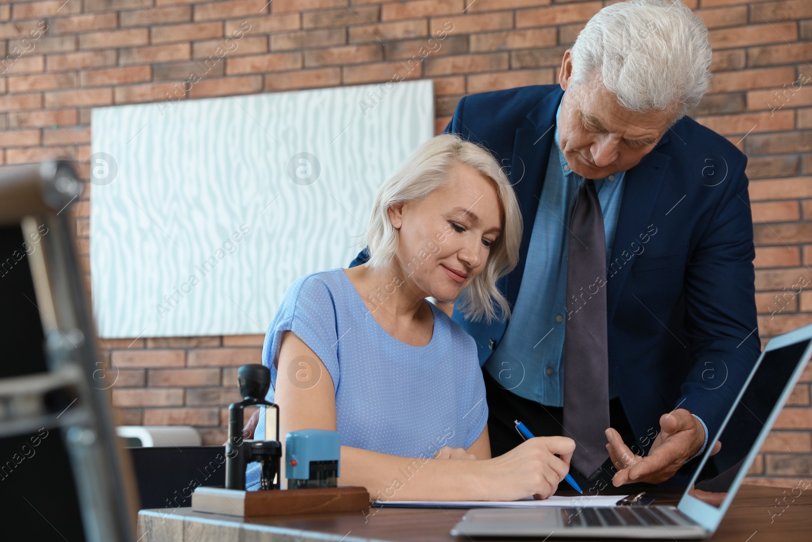 Photo of Senior notary working with client in office