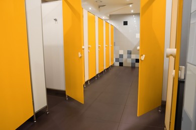 Photo of Public toilet interior with bright yellow stalls