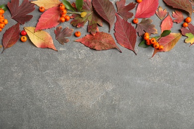 Photo of Flat lay composition with autumn leaves on grey stone background. Space for text