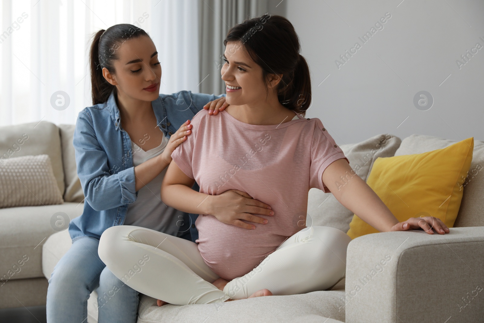 Photo of Doula working with pregnant woman in living room. Preparation for child birth