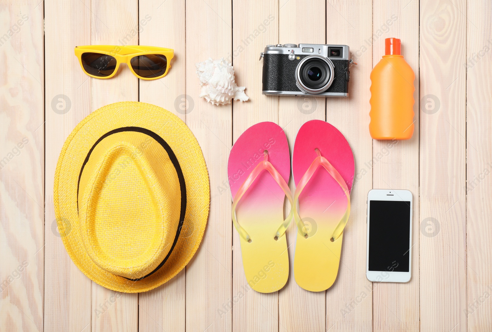 Photo of Flat lay composition with beach objects and mobile phone on wooden background