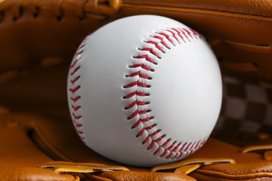 Photo of Leather baseball glove with ball, closeup. Sportive equipment