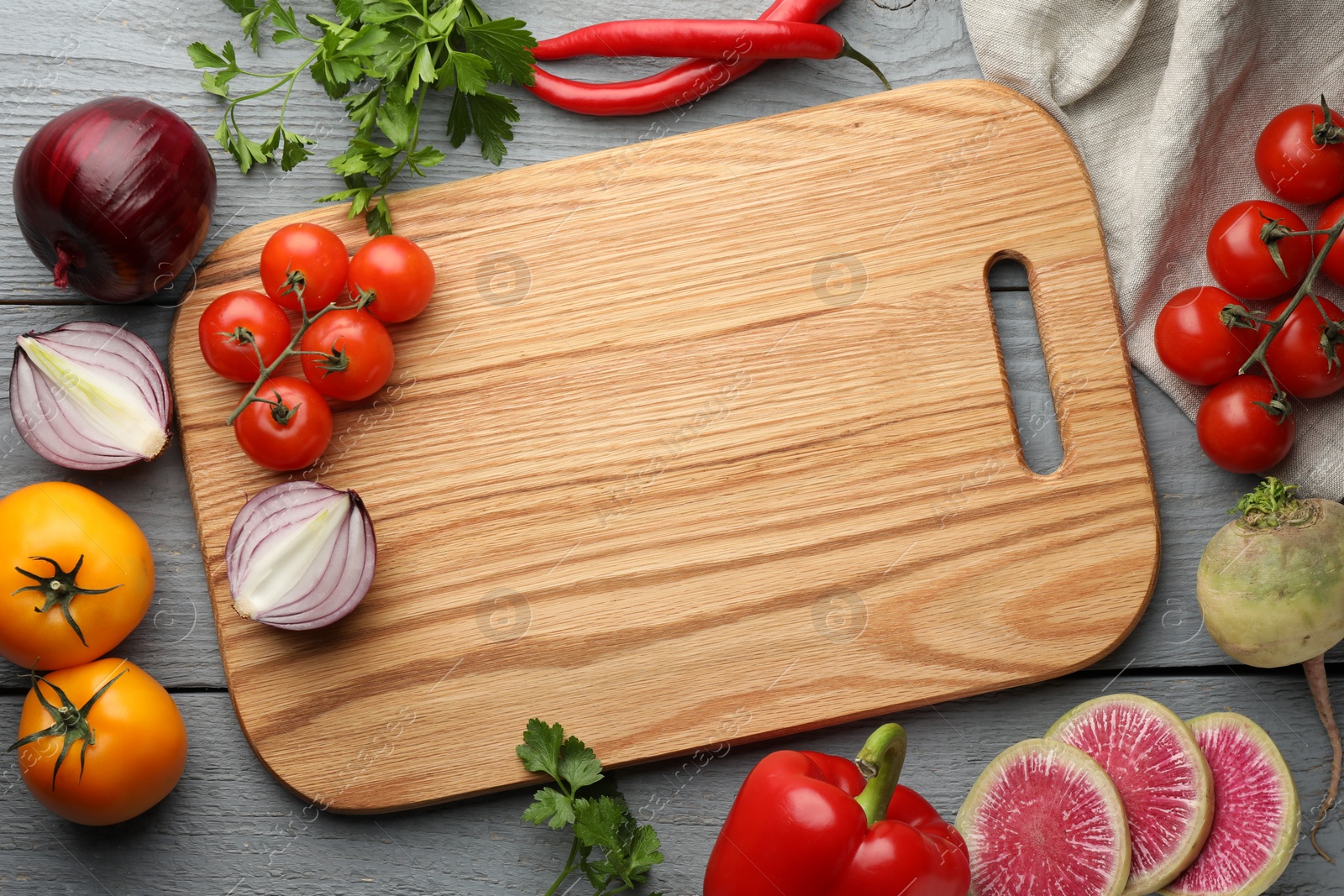 Photo of Flat lay composition with cutting board and products on grey wooden table