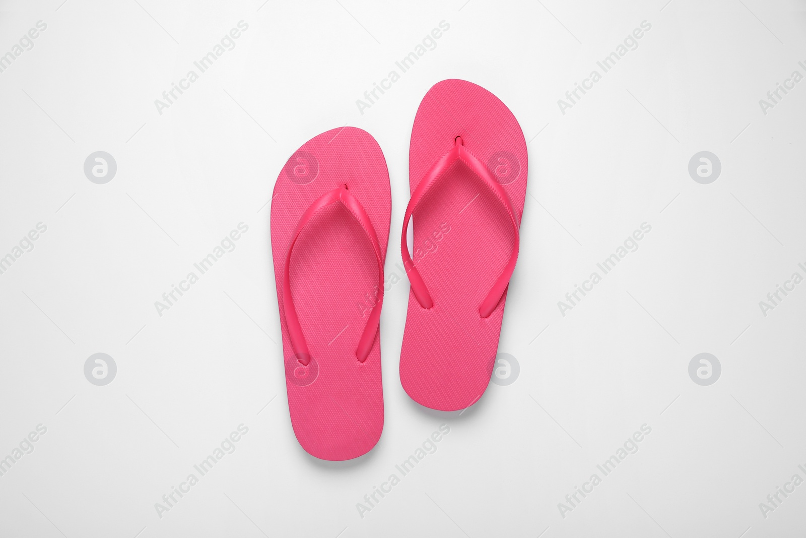 Photo of Stylish pink flip flops on white background, top view