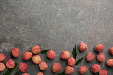 Photo of Fresh ripe lychee fruits on grey table, flat lay. Space for text