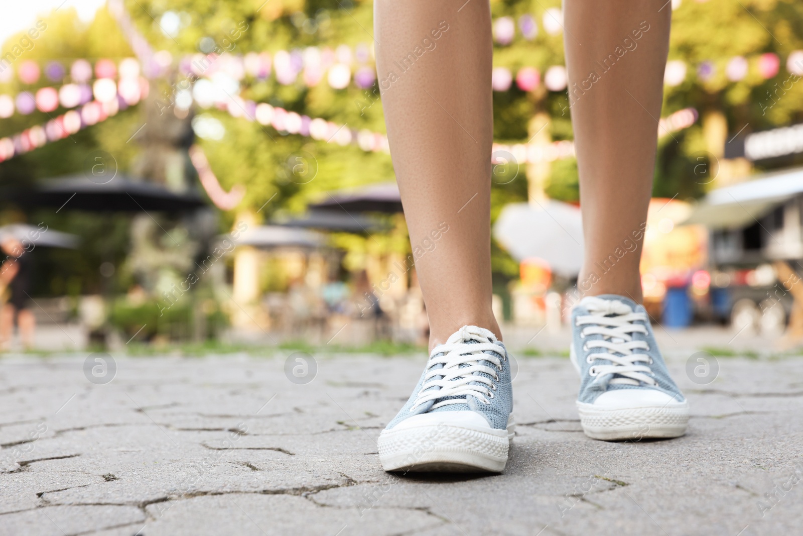 Photo of Woman in stylish shoes walking on city street, closeup. Space for text