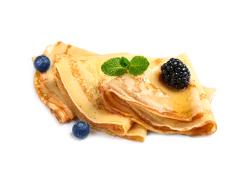 Photo of Delicious thin pancakes with berries on white background