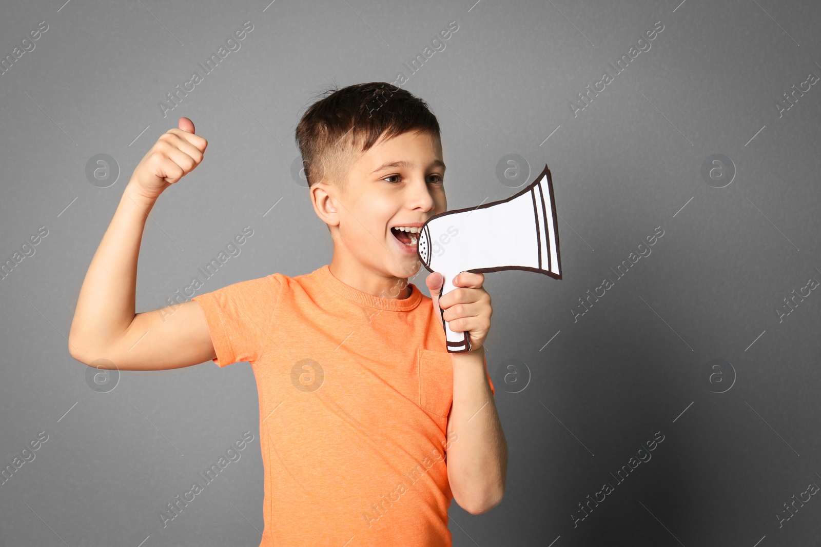 Photo of Cute little boy with paper megaphone on grey background