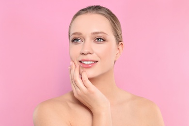 Portrait of young woman with beautiful face on pink background