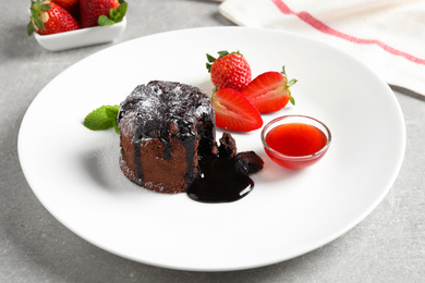 Photo of Delicious warm chocolate lava cake on grey table