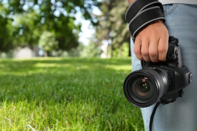 Image of Professional photographer with modern camera and blurred view of park, space for text