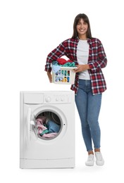 Beautiful woman with laundry basket near washing machine on white background