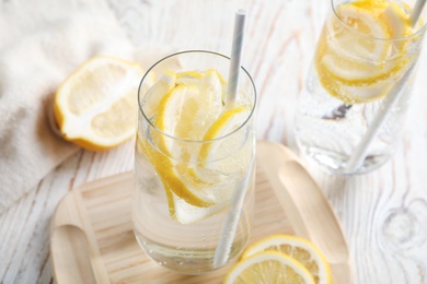 Photo of Soda water with lemon slices and fresh fruits on white wooden table