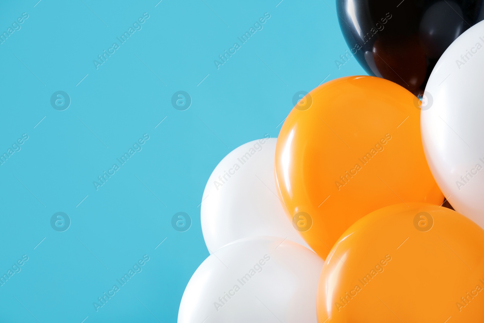 Photo of Colorful balloons on blue background, space for text. Halloween party