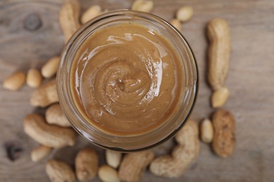 Tasty peanut nut paste in jar on table, top view