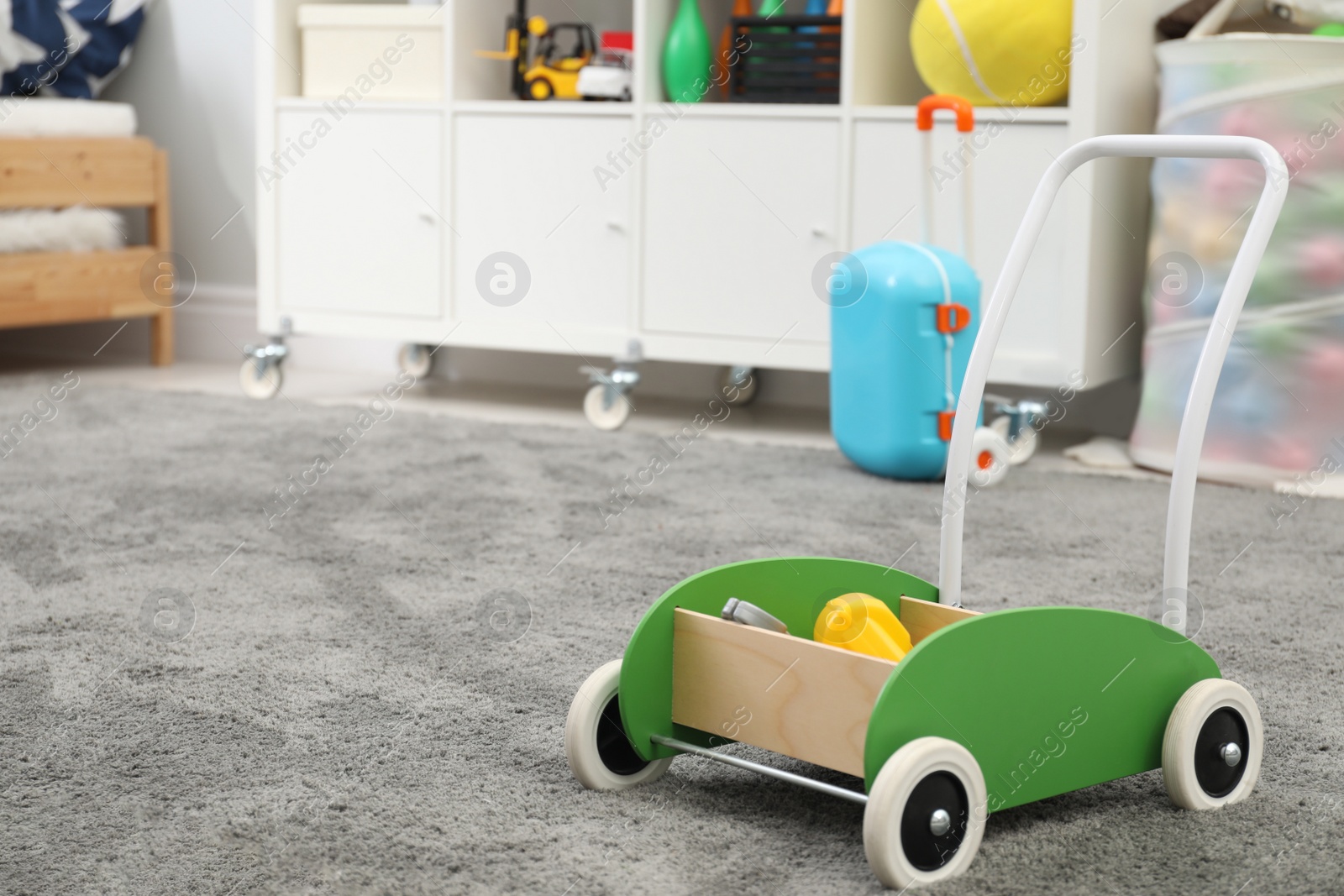 Photo of Toy walker on floor in child's room, space for text. Interior design