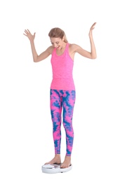 Photo of Happy young woman measuring her weight using scales on white background. Weight loss motivation