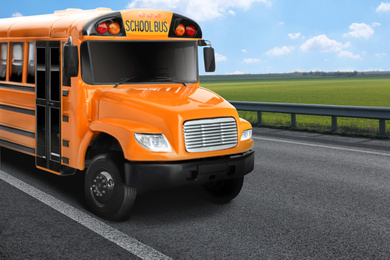 Image of Yellow school bus on road outdoors. Transport for students