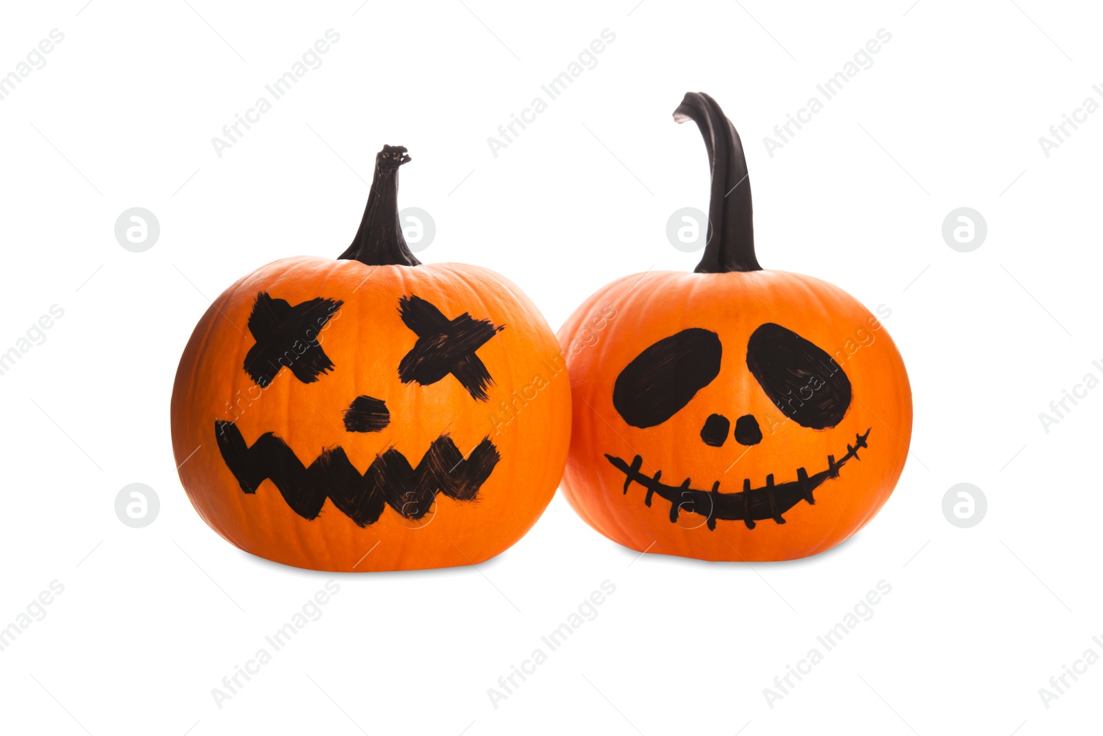 Photo of Halloween pumpkins with scary drawn faces on white background