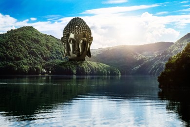 Image of Majestic Buddha sculpture near lake and mountains on sunny day 