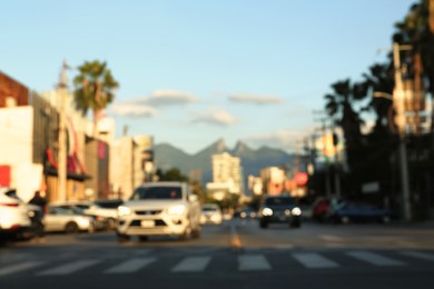 Photo of Blurred view of cityscape with cars on road near beautiful buildings