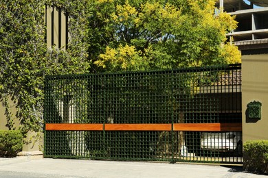 Photo of Security metal gates near trees and estate outdoors