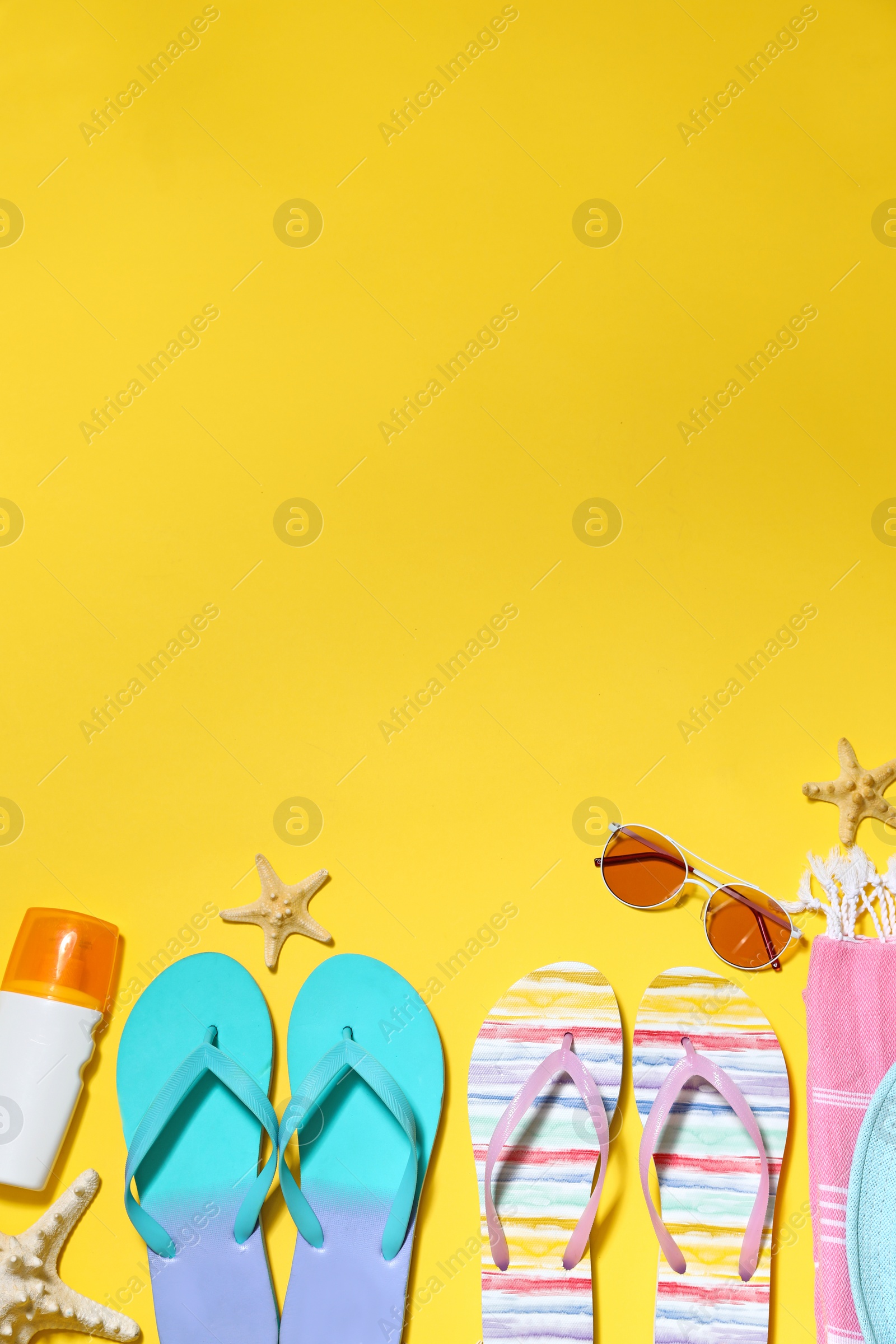 Photo of Flat lay composition with summer beach accessories on yellow background. Space for text