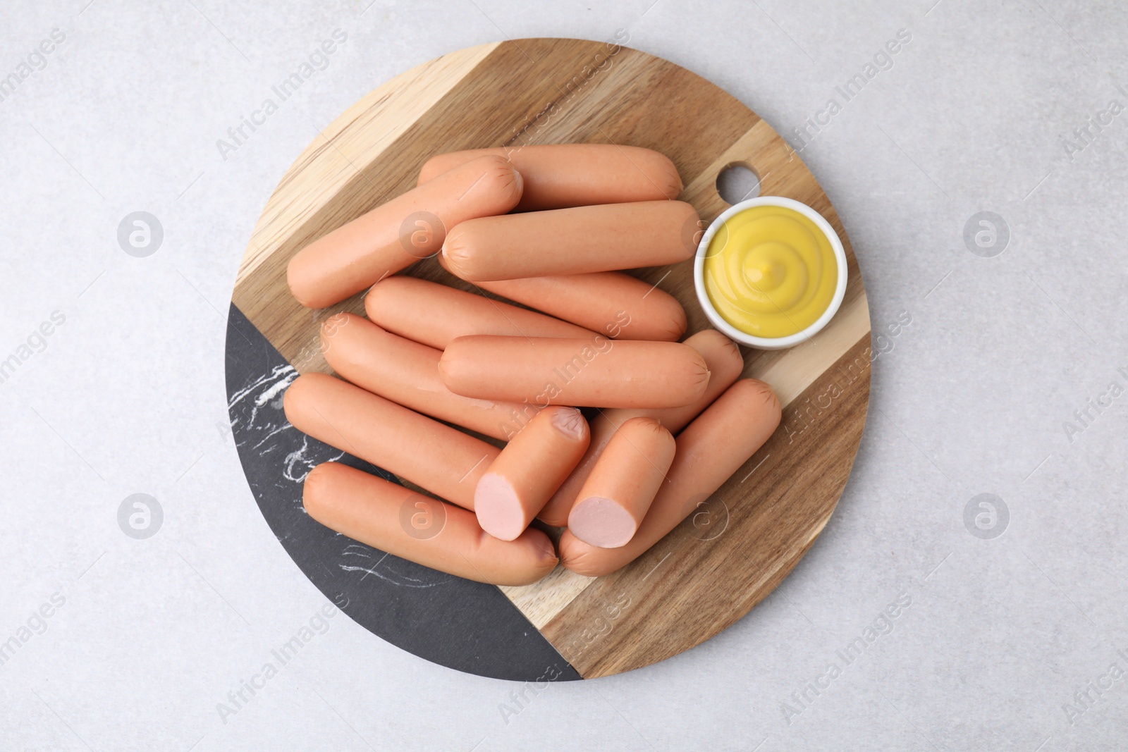 Photo of Delicious boiled sausages and sauce on light gray table, top view