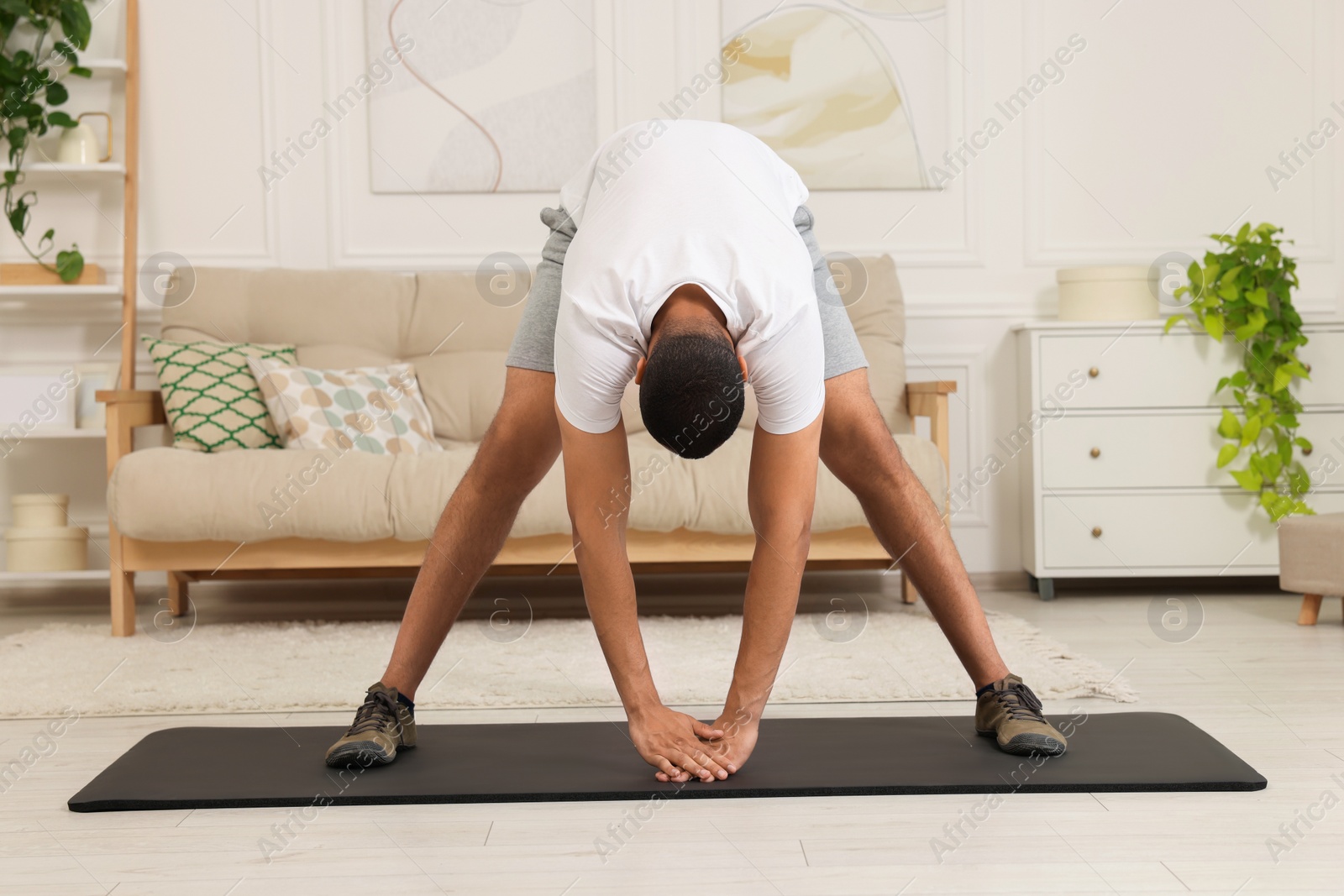 Photo of Man doing morning exercise on fitness mat at home