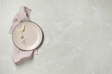 Photo of Elegant plate with spikes and napkin on marble table, top view. Space for text