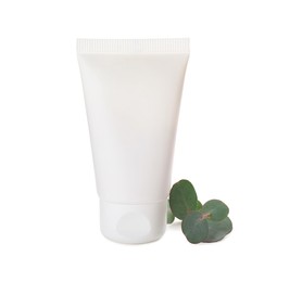 Photo of Tube of hand cream and eucalyptus on white background