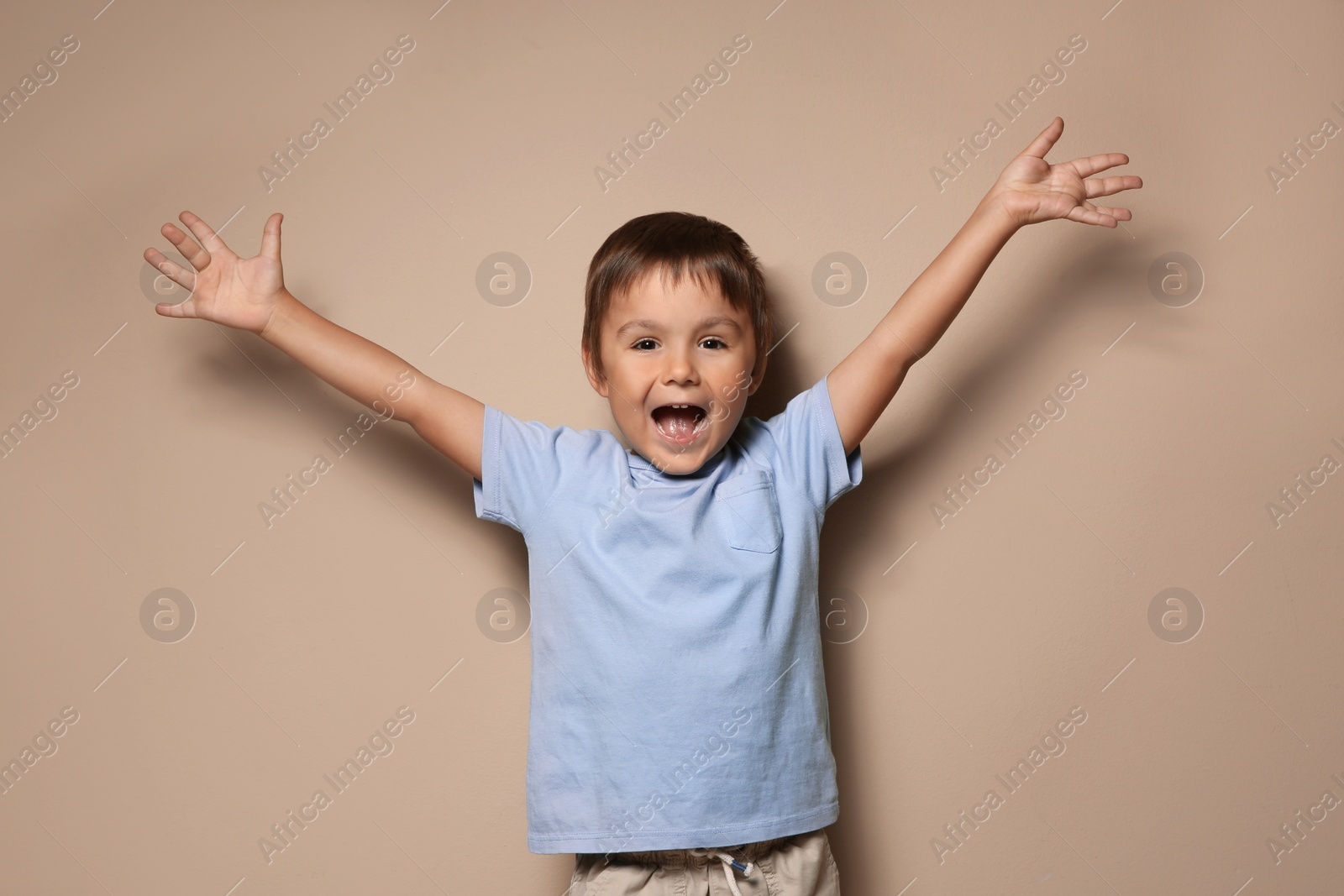 Photo of Portrait of happy little boy on beige background