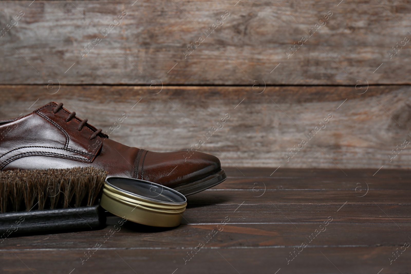 Photo of Footwear and shoe shine kit on wooden table, space for text