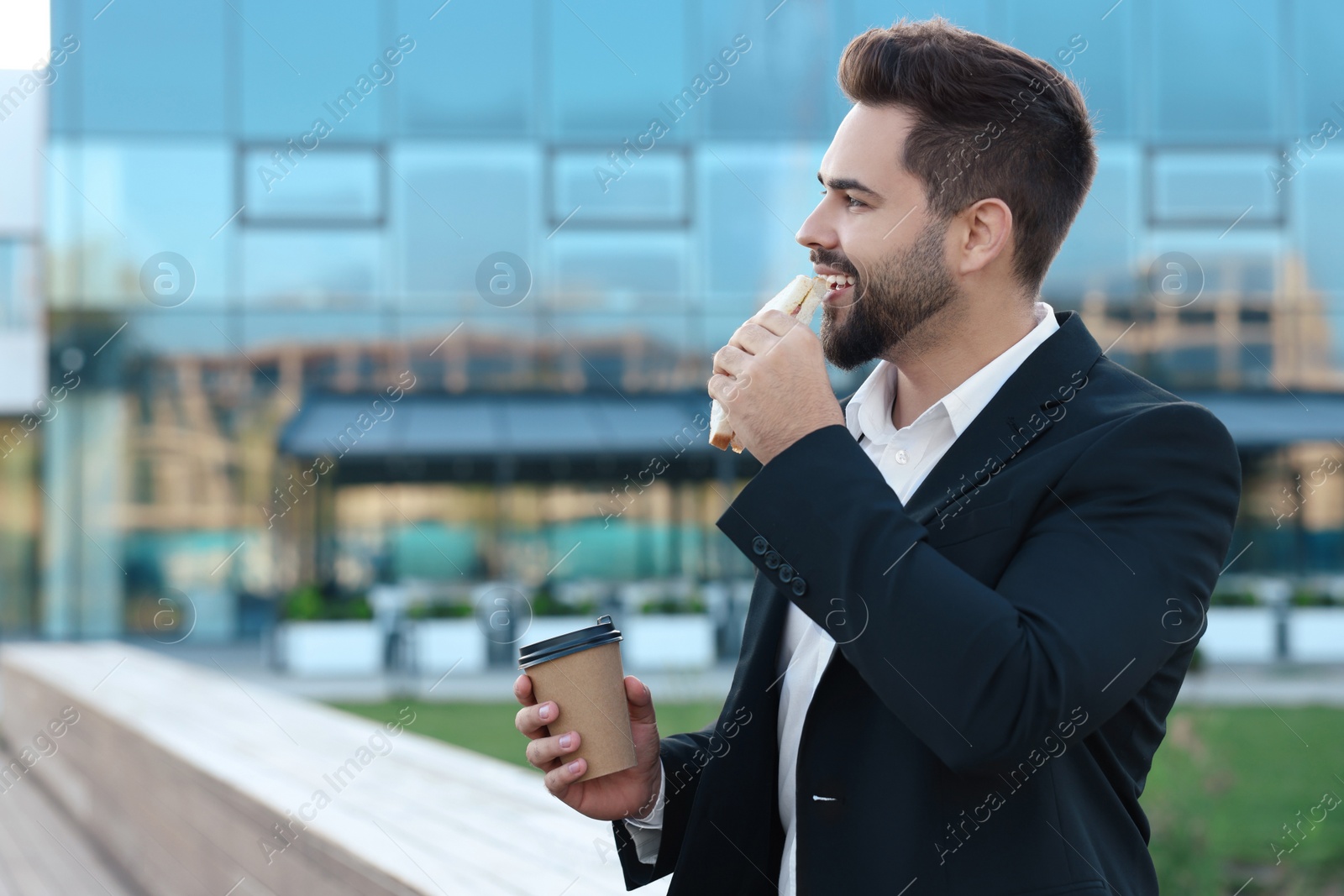 Photo of Smiling businessman having his lunch outdoors. Space for text