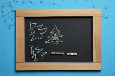 Photo of Flat lay composition with chalkboard, words Winter Break and Christmas decor on light blue background. School holidays